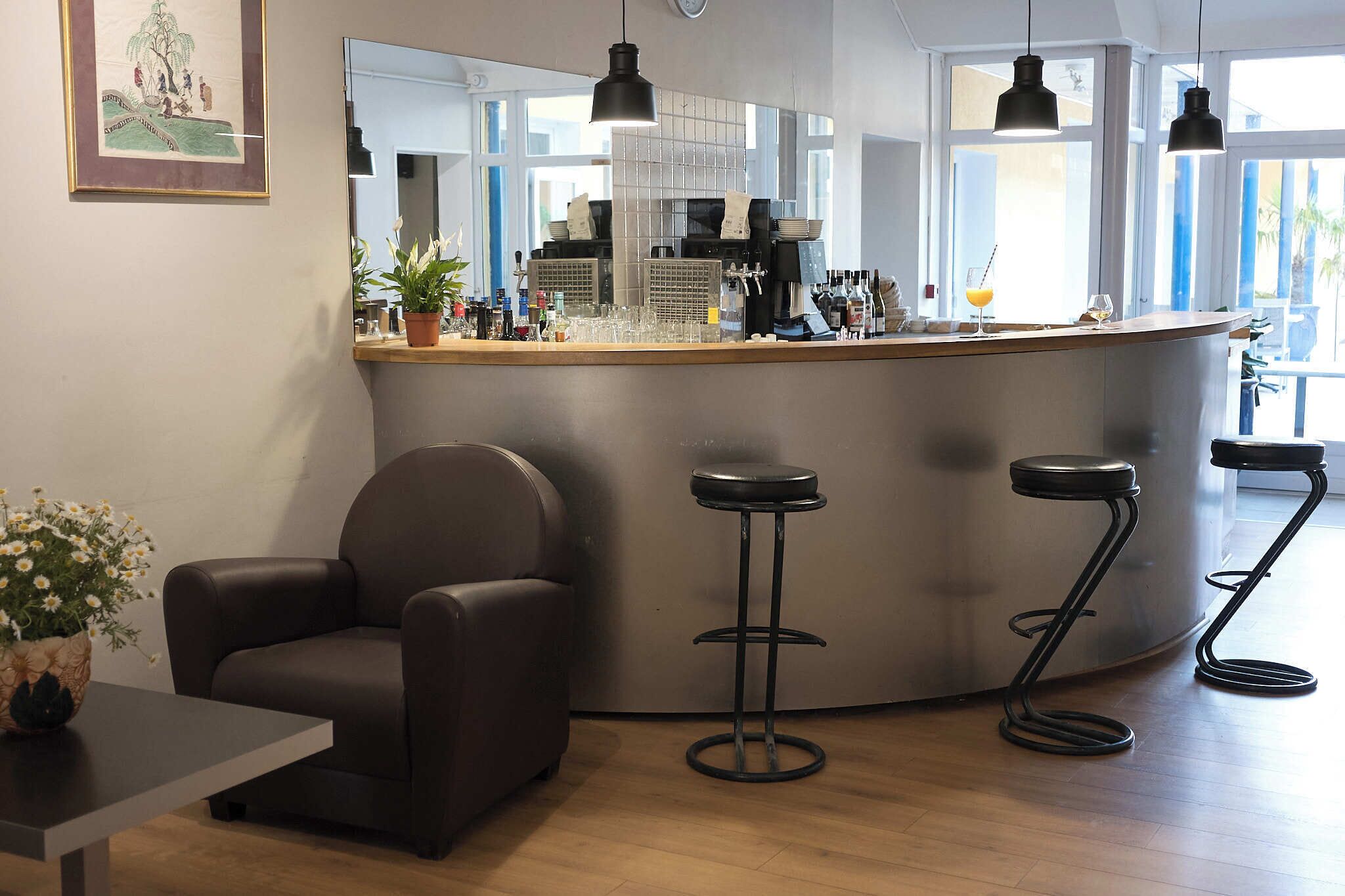 Zona de bar con taburetes, mostrador y máquina de café.