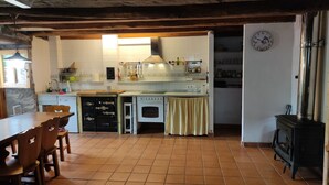 Uma cozinha com fogão, forno e um relógio na parede.