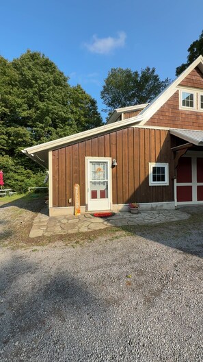 A building with a wooden exterior, a welcome sign, a door, and a small window.
