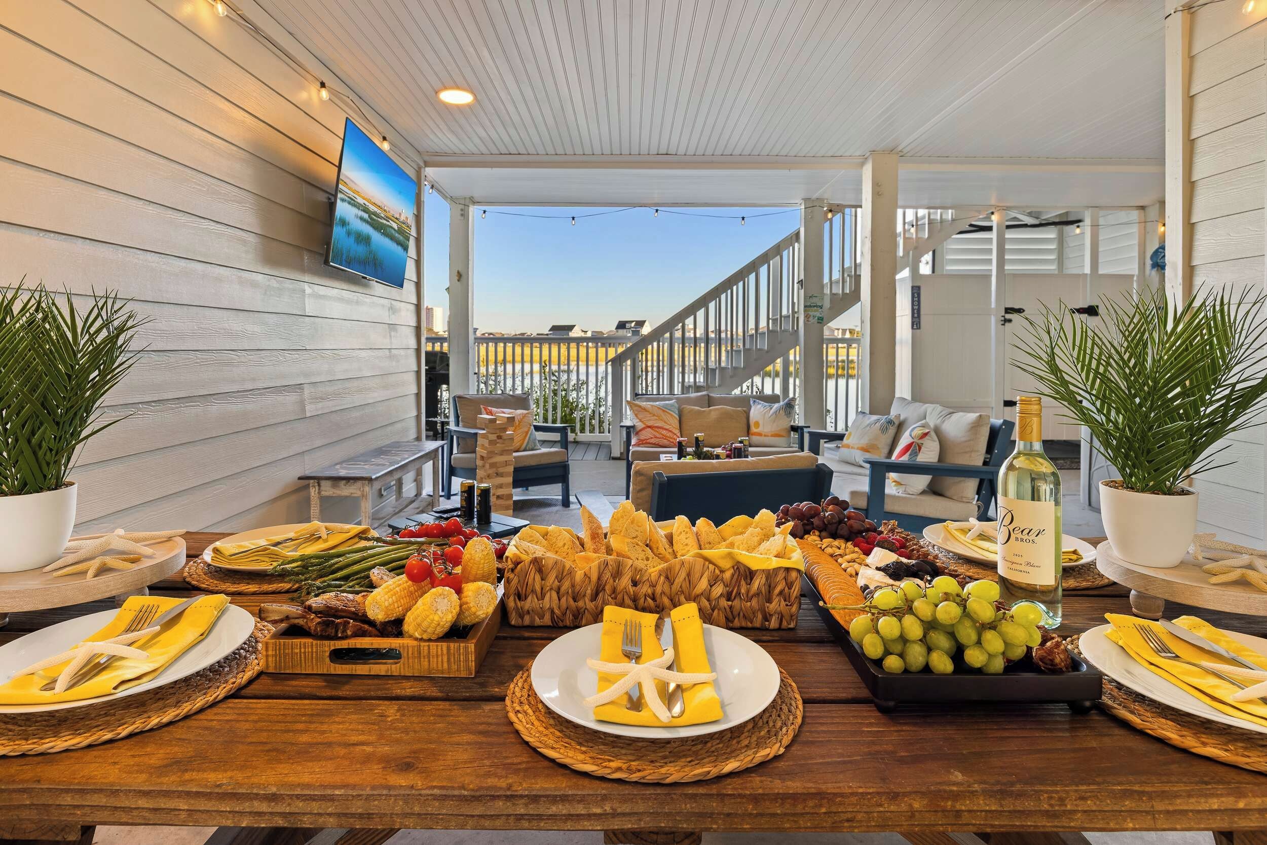 A dining area with a table set for a meal, featuring a variety of foods and a bottle of wine.