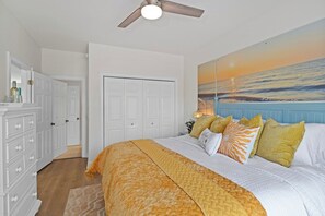 A bedroom with a bed, a ceiling fan, a painting of a sunset, and a white wardrobe. - 5 BR WaterFront Pool/Hottub/Elevator Sleeps 16 (North Myrtle Beach)