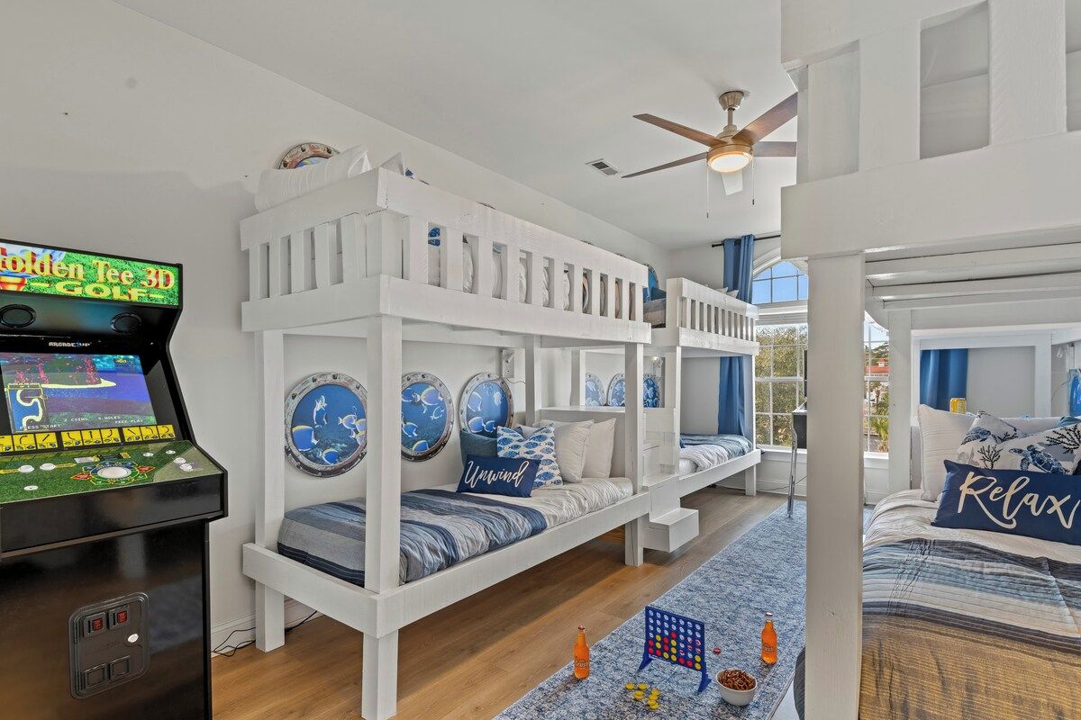 Quarto com beliche, console de videogame de golfe em 3D, decoração náutica e vista para o exterior.