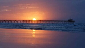 A pier extending into the water with a sunset in the background. - Sunset Serenity marsh view w/pool (North Myrtle Beach)