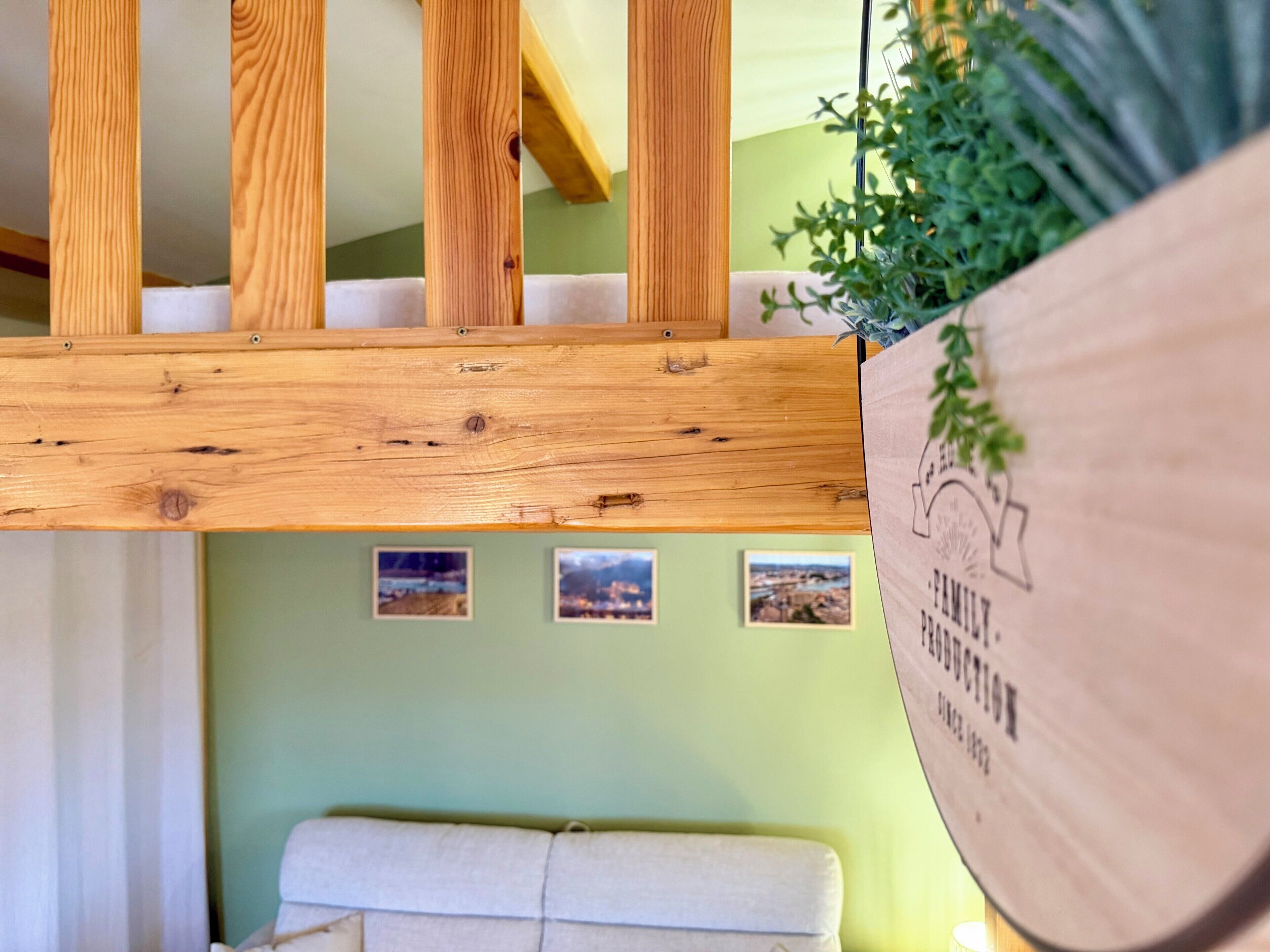 Une pièce de style « loft », avec un plafond en bois, un banc rembourré et des tableaux encadrés accrochés au mur.