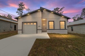 A single-story house with a garage, a front door, and two windows.
