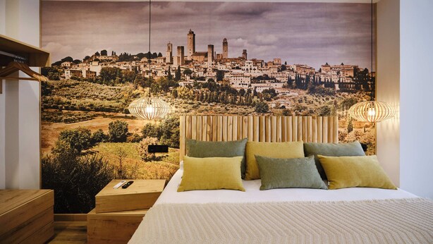 A bedroom with a cityscape mural, a wooden headboard, and two bedside lamps. - Premium Suite Toscana, non-smoking (Avilés)