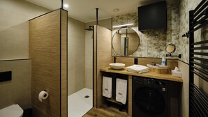 A modern bathroom with a wooden partition, a sink with a mirror, a washing machine, and a toilet. - Premium Suite Toscana, non-smoking (Avilés)