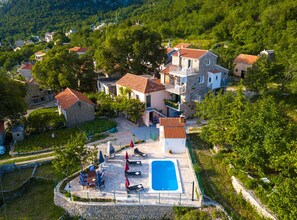 A residential area with stone buildings, a swimming pool, and outdoor seating. - Villa Roza Dalmatian Escape (Tucepi)