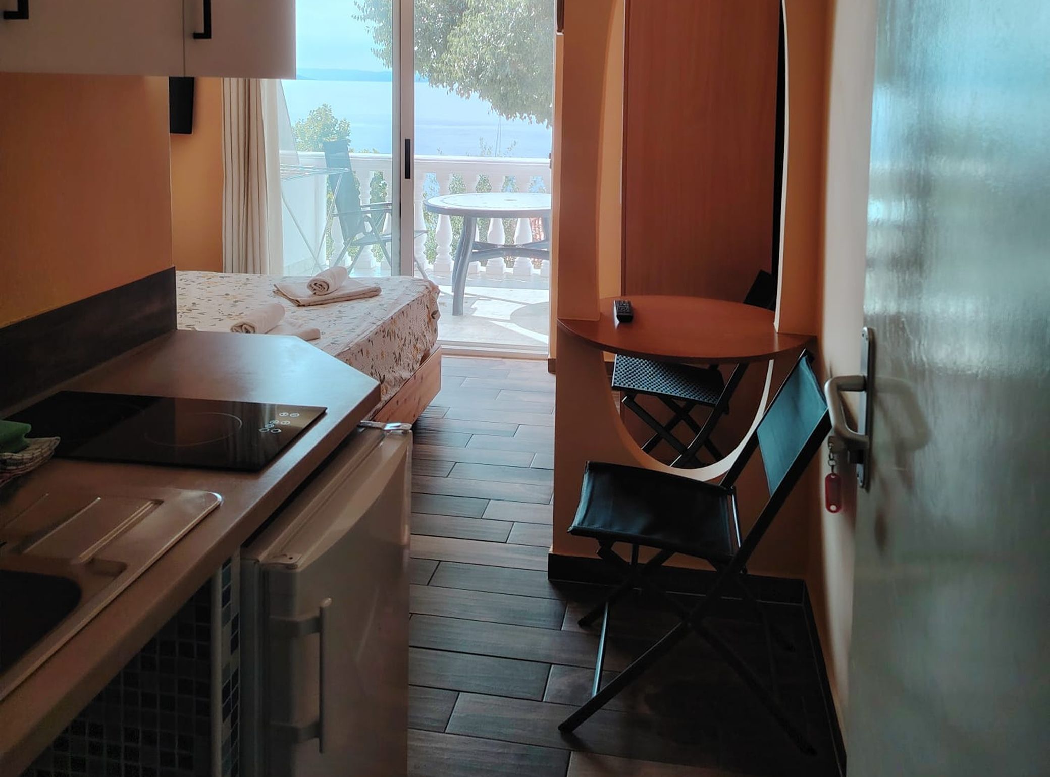 A compact kitchen with a dining area, a small table, and a view of the outdoors.