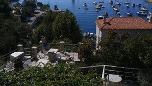 A coastal town with a marina, stone buildings, and a prominent sailboat in the distance. - Comfort Kostrena Apartments Rijeka (Kostrena)