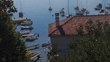 Ein Yachthafen mit vertäuten Booten, ein Gebäude mit Ziegeldach und freier Wasserblick.