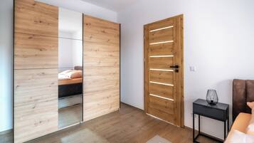Ein modernes Schlafzimmer mit einem Holzschrank, einem Nachttisch und einem Bett mit Kopfteil.