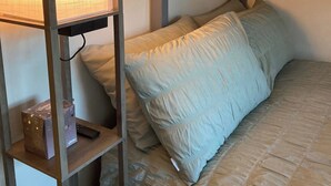 A bunk bed with a headboard, a bedside table with a lamp, and a shelf with a box. - Wimbleball Lake View Cabin Sleeps up to 3 (Dulverton)