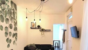 Une chambre à coucher moderne avec un grand lit, un canapé, une télévision et un luminaire au plafond.