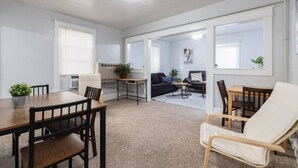 Una sala de estar moderna con una mesa de comedor, sillas, un sofá y una pequeña mesa de centro.