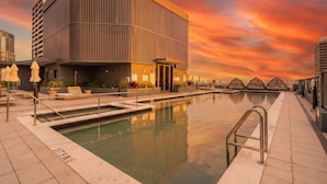 A modern building with a pool, outdoor seating, and a sunset sky. - Stay Central in Miami - Panoramic views of Biscayne Bay (Miami)