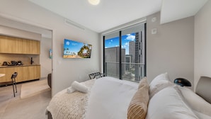 A modern hotel room with a bed, a desk, and a large window with a city view. - Stay Central in Miami - Panoramic views of Biscayne Bay (Miami)