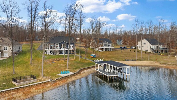 A lakeside residential area with houses, a dock, and a small pier. - Fairview Lake Haven | New Waterfront Home | Private Side | 6BR/4BA | Boathouse & Dock (Mineral)