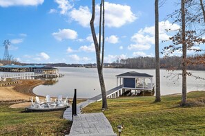 Boathouse - The path from the fire pit leads to the covered boathouse over the water, with Adirondack chairs and a kayak rack along the way. - Fairview Lake Haven | New Waterfront Home | Private Side | 6BR/4BA | Boathouse & Dock (Mineral)