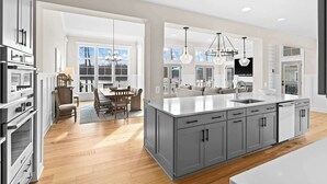 A modern kitchen with a large island, built-in appliances, and pendant lighting. - Fairview Lake Haven | New Waterfront Home | Private Side | 6BR/4BA | Boathouse & Dock (Mineral)