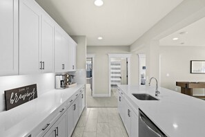 Lower Level Bar - White cabinetry, quartz countertop, and a full setup including a beverage fridge and coffee station. - Fairview Lake Haven | New Waterfront Home | Private Side | 6BR/4BA | Boathouse & Dock (Mineral)
