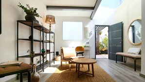 A modern living room with a sofa, a coffee table, a bookshelf, and a window. - Villa Tharros - Playa del Inglés (Playa del Ingles)