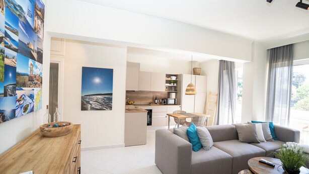 A modern living room with a sofa, a coffee table, and a dining area. - Modern central apartment for couples with 2 balconies - relax in style (Rodos)