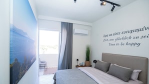 A bedroom with a bed, a wall-mounted air conditioner, a potted plant, and a view of the outdoors. - Modern central apartment for couples with 2 balconies - relax in style (Rodos)