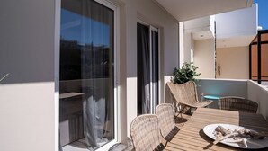 A balcony with a table and chairs, a potted plant, and a view of the sky. - Modern central apartment for couples with 2 balconies - relax in style (Rodos)