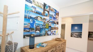 A hallway with a wooden cabinet, a wall collage of travel photos, and a wooden ladder leaning against the wall. - Modern central apartment for couples with 2 balconies - relax in style (Rodos)