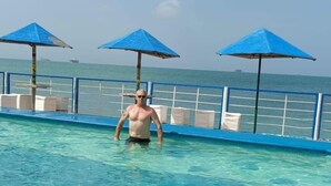A man in a swimming pool with clear water, blue umbrellas, and a railing. - Beautiful mansion available, pet friendly (Punto Fijo)