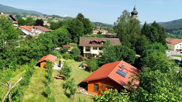A rural village with traditional houses, a church, and a large house with a red roof. - Sonnenfleckerl Vacation Rental, 100 square meters (Drachselsried)