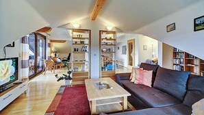 A spacious living area with a sofa, coffee table, and bookshelves. - Sonnenfleckerl Vacation Rental, 100 square meters (Drachselsried)