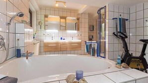 A bathroom with a bathtub, a shower, a toilet, a sink, and a towel rack. - Sonnenfleckerl Vacation Rental, 100 square meters (Drachselsried)