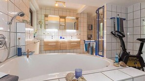 A bathroom with a bathtub, a shower, a toilet, a sink, and a towel rack. - Vacation apartment "Sonnenfleckerl" approx. 100 sqm *****DTV classification (Drachselsried)