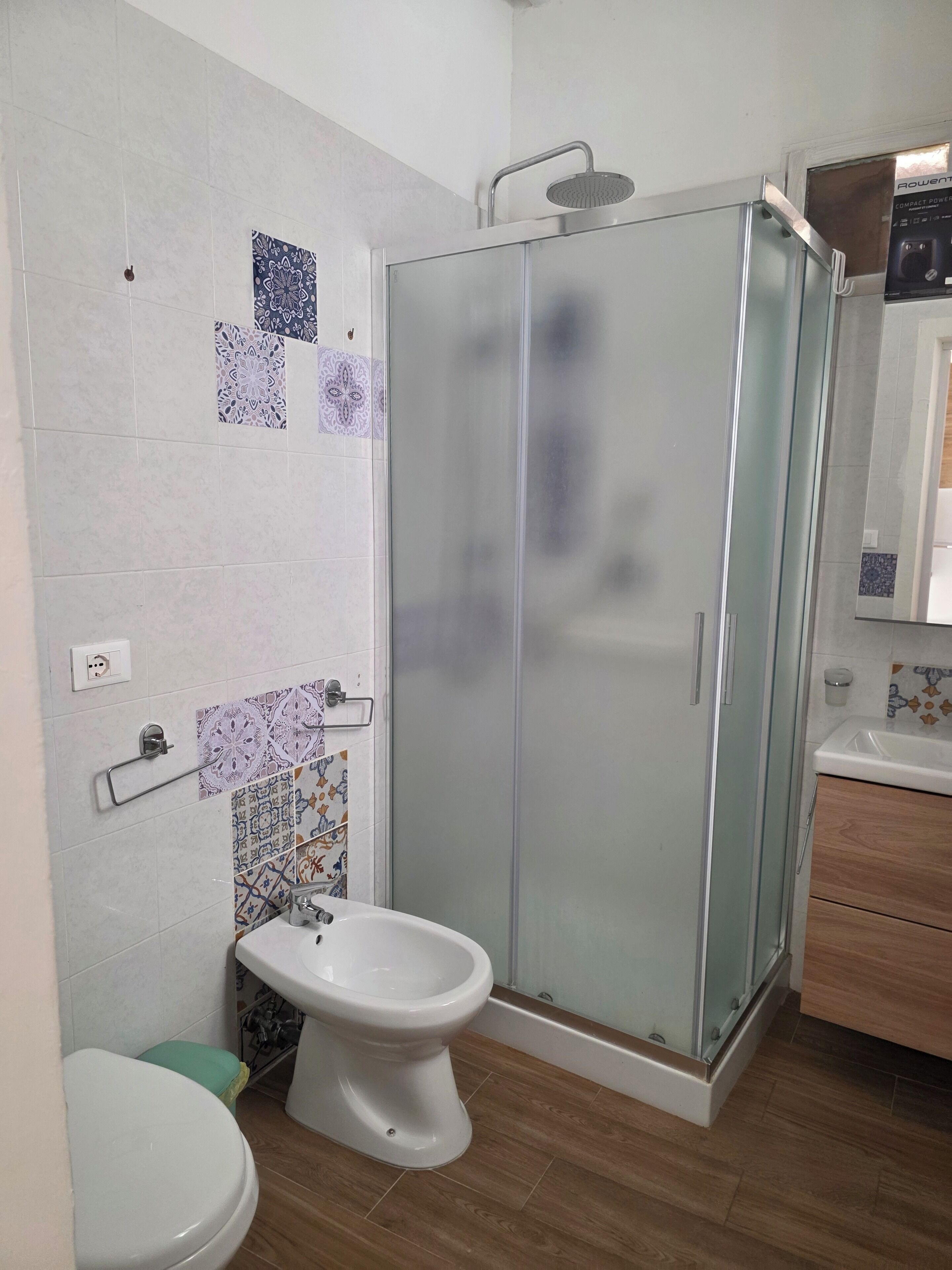 A bathroom with a shower, toilet, and sink.