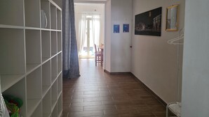 A hallway with a tiled floor, a white air conditioning unit, a patterned curtain, and a framed picture on the wall. - Maty's House 2 steps from the sea (40 mt) (Reggio Calabria)
