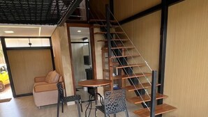 Een modern interieur met een trap, een eethoek en een bank.