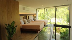 Ein modernes Schlafzimmer mit zwei Betten, großen Fenstern und Blick auf Grünflächen.