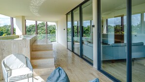 Un intérieur moderne avec un balcon, un coin salon et de grandes fenêtres.