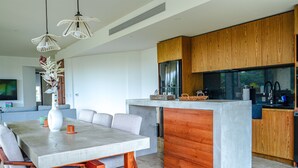 Une cuisine moderne avec des meubles en bois, un îlot central et des luminaires suspendus.