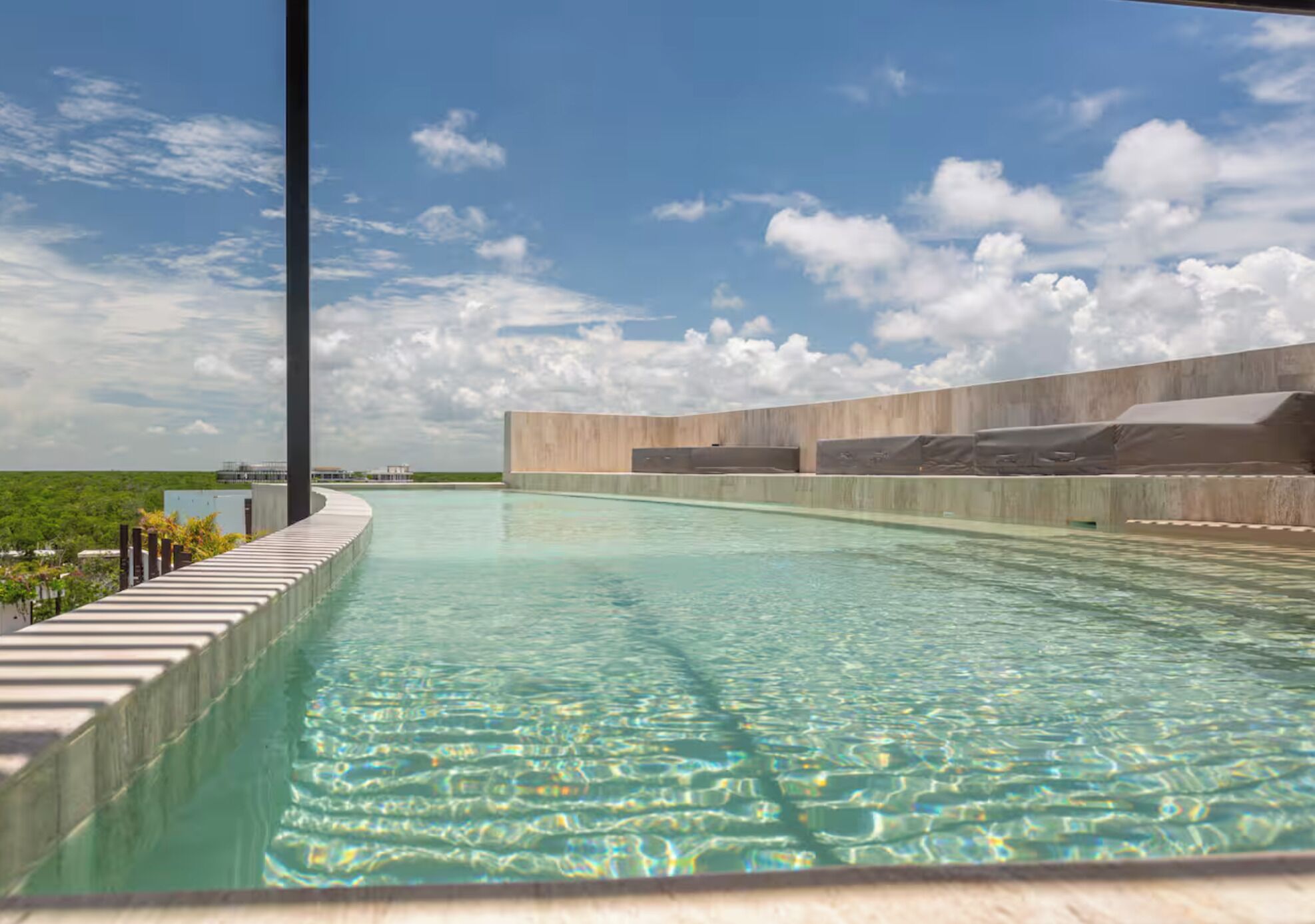 Une piscine offrant une vue dégagée sur le ciel et la verdure environnante.
