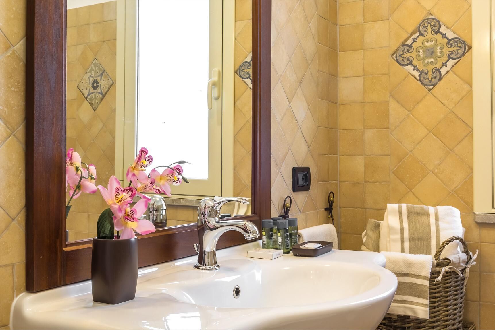 Une salle de bain avec un lavabo, un miroir et des carreaux décoratifs.