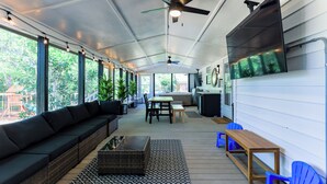 A covered porch with a sofa, table, chairs, and a ceiling fan. - Hot Tub, Pool Table, Ping-Pong, Private Playground, Fire Pit, Library, Play Room (Valdosta)
