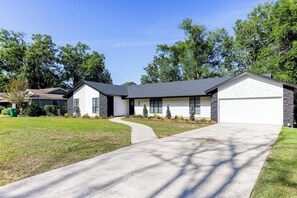 A two-story house with a driveway, a front lawn, and a garage.