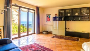 Un salon comprenant un canapé, une table basse, une cheminée et une vue sur l’extérieur.