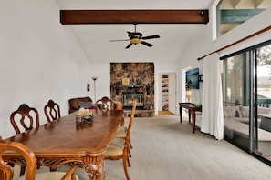 A dining room with a stone fireplace, wooden dining table, and chairs. - Vivienda de Osos #2549 (Fawnskin)