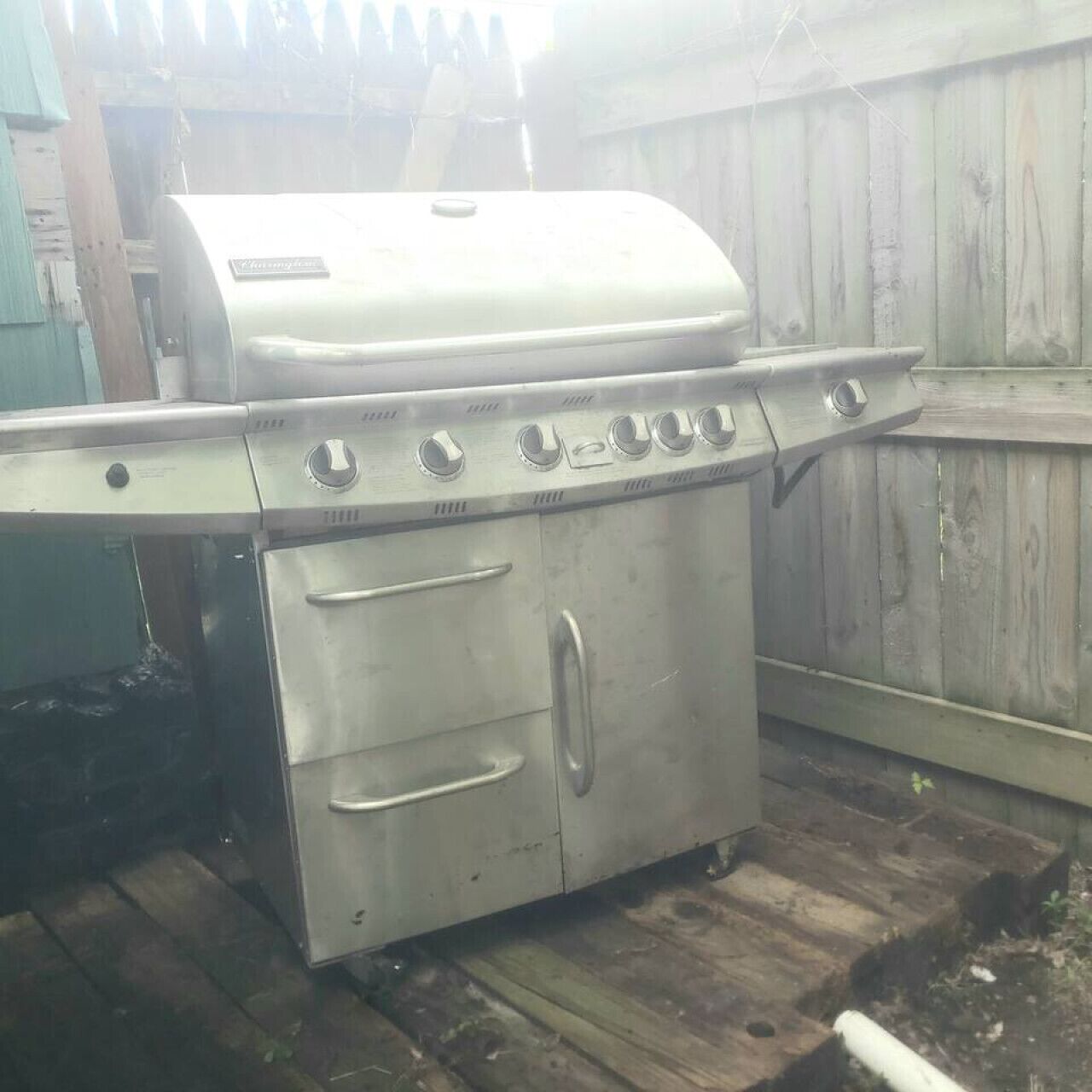Una parrilla de acero inoxidable para exteriores con un panel de control, una puerta de horno y una superficie plana.