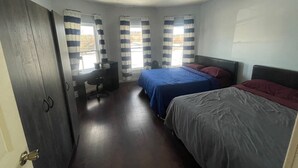 Ein Schlafzimmer mit zwei Betten, einem Schreibtisch und einem Stuhl.