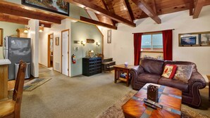 A cozy living room with a brown leather sofa, a wooden coffee table, and a fireplace. - Oakwood Cottage #2582 (Sugarloaf)